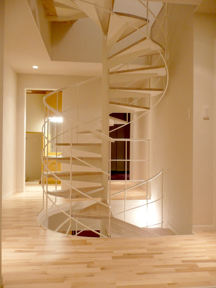 Modern wood spiral staircase in Fukuoka with open risers.