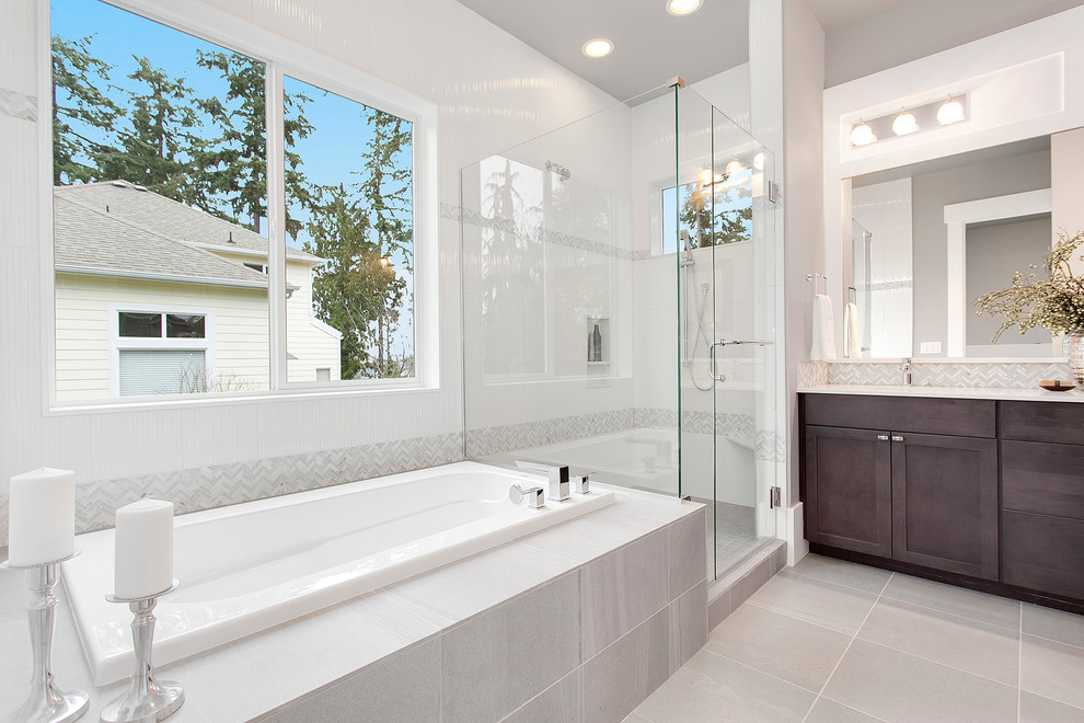 Photo of a large transitional master bathroom in Seattle with flat-panel cabinets, dark wood cabinets, a drop-in tub, an alcove shower, gray tile, grey walls, an undermount sink and engineered quartz benchtops.