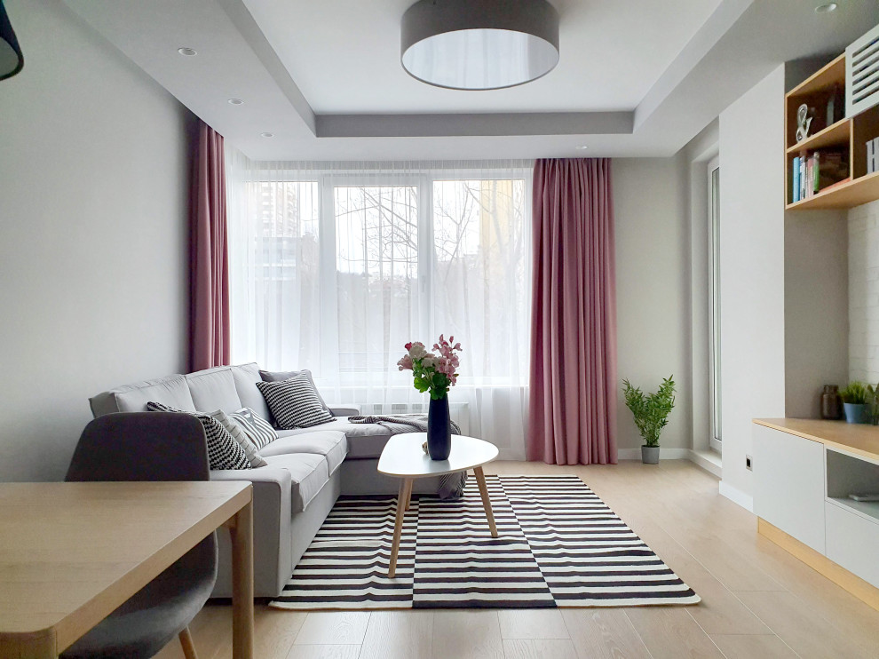 Photo of a small contemporary grey and pink open plan living room with grey walls, beige floors and brick walls.