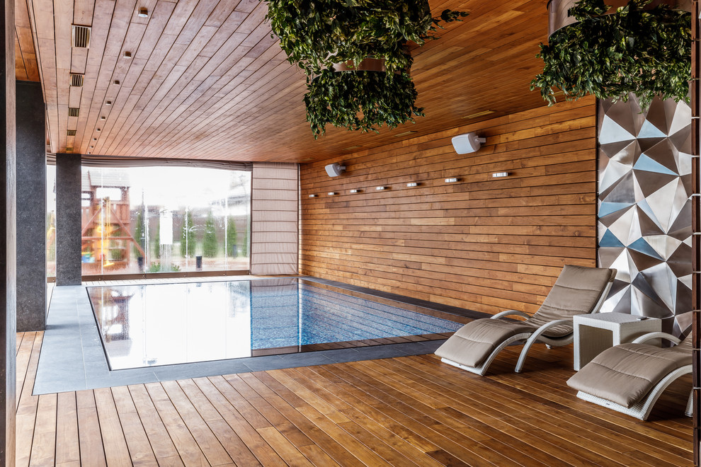 Inspiration for an eclectic indoor rectangular pool in Other with decking.