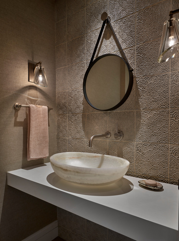 Inspiration for a small transitional powder room in Chicago with beige tile, ceramic tile, beige walls, a vessel sink, engineered quartz benchtops, beige benchtops, a floating vanity and wallpaper.