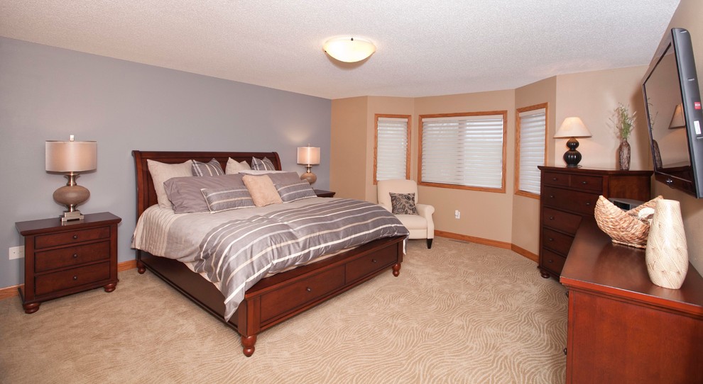 Photo of a large traditional master bedroom in Other with beige walls and carpet.