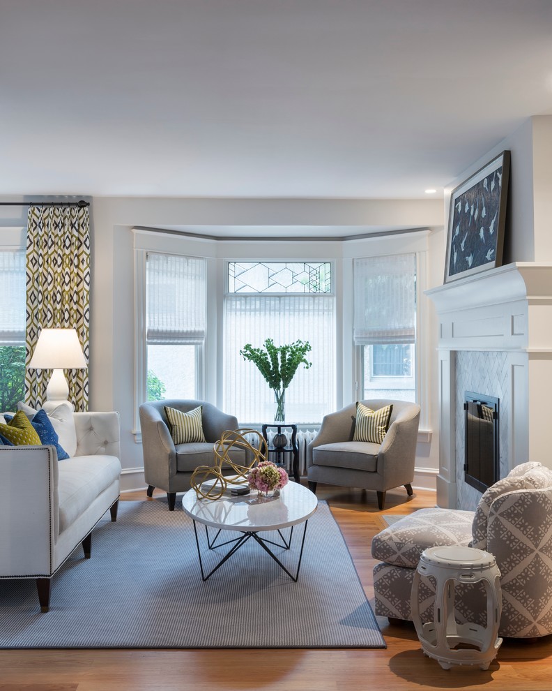 Inspiration for a large transitional formal medium tone wood floor living room remodel in Minneapolis with white walls, a standard fireplace, a tile fireplace and no tv