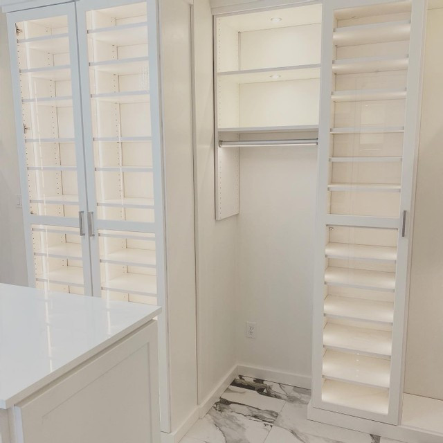 Immagine di una cabina armadio unisex moderna con ante in stile shaker, ante bianche, pavimento in marmo e pavimento bianco