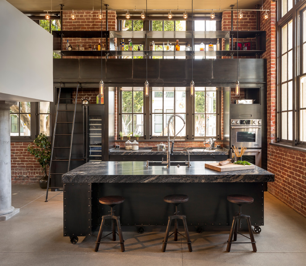 This is an example of an industrial galley eat-in kitchen in Other with flat-panel cabinets, stainless steel appliances, concrete floors and with island.
