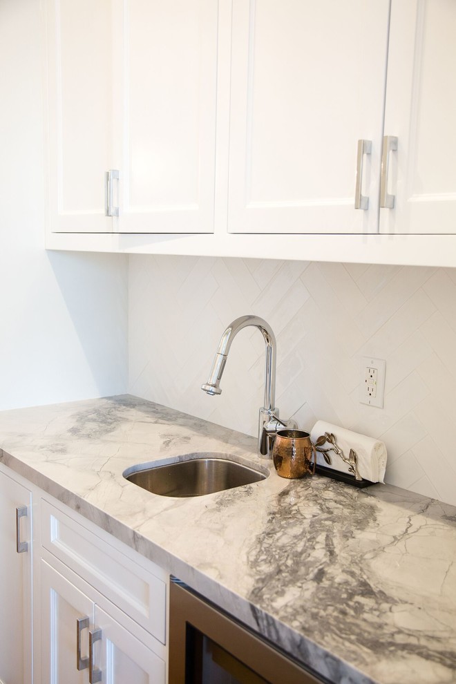 Inspiration for a huge transitional u-shaped porcelain tile and gray floor kitchen remodel in Los Angeles with an undermount sink, shaker cabinets, white cabinets, quartzite countertops, white backsplash, ceramic backsplash, stainless steel appliances and an island
