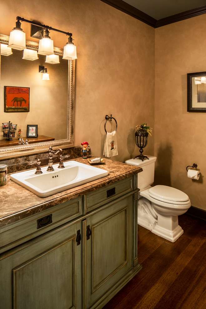 Photo of a small arts and crafts powder room in Santa Barbara with furniture-like cabinets, beige walls, medium hardwood floors, a drop-in sink, blue cabinets, a two-piece toilet and marble benchtops.