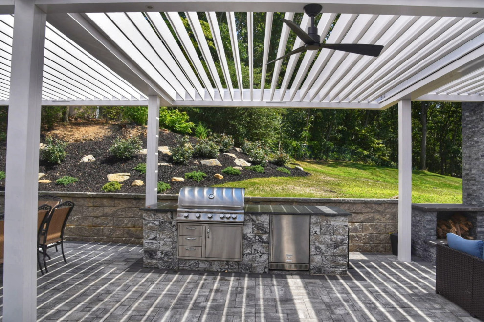 Foto de patio tradicional de tamaño medio en patio trasero con adoquines de hormigón y pérgola