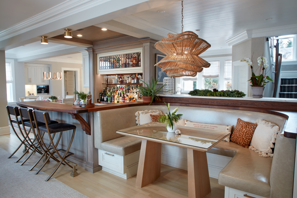 Inspiration for a large classic dining room in New York with light hardwood flooring, banquette seating, beige walls and beige floors.