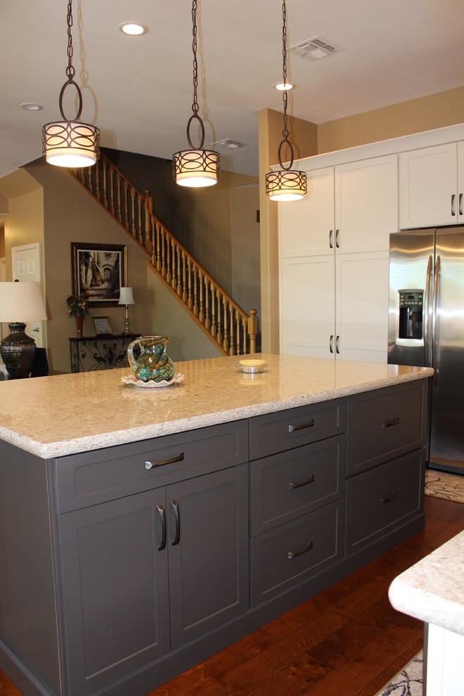 Example of a mid-sized transitional l-shaped dark wood floor and brown floor open concept kitchen design in Phoenix with an undermount sink, shaker cabinets, white cabinets, granite countertops, white backsplash, subway tile backsplash, stainless steel appliances and an island