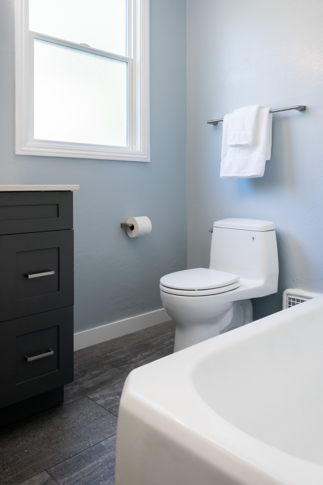 Medium sized modern ensuite bathroom in San Francisco with shaker cabinets, brown cabinets, engineered stone worktops, a single sink, a built in vanity unit, a corner bath, an alcove shower, a one-piece toilet, white tiles, ceramic tiles, blue walls, cement flooring, a submerged sink, grey floors, a sliding door, white worktops and a wall niche.