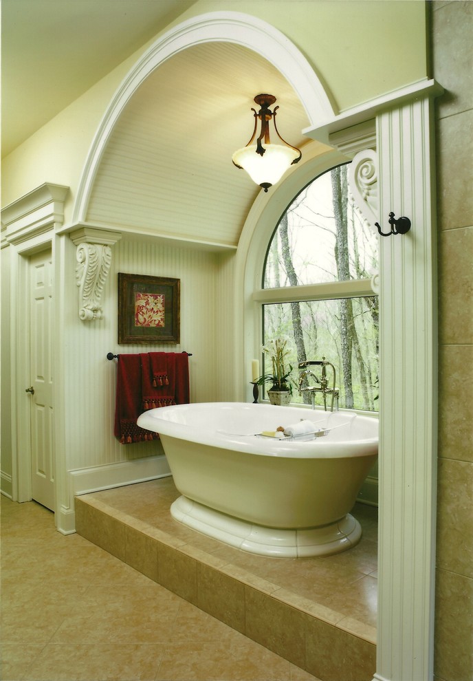 This is an example of a mid-sized traditional master bathroom in Other with white cabinets, a freestanding tub, ceramic tile, beige walls, ceramic floors and marble benchtops.
