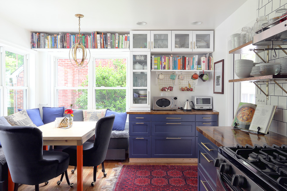 Small midcentury galley eat-in kitchen in DC Metro with recessed-panel cabinets, blue cabinets, wood benchtops, white splashback, medium hardwood floors and brown benchtop.