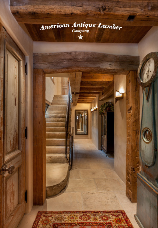 Photo of a large country hallway with beige walls, travertine floors and beige floor.
