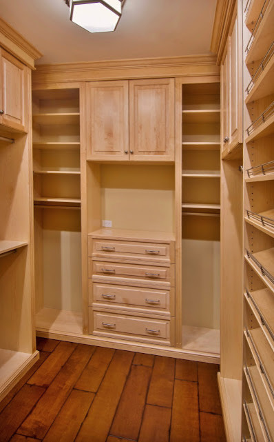 Design ideas for a mid-sized traditional walk-in wardrobe in New York with raised-panel cabinets, light wood cabinets and dark hardwood floors.