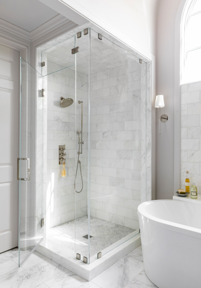 Klassisches Badezimmer mit weißen Schränken, freistehender Badewanne, Marmorboden, weißem Boden, Doppelwaschbecken und eingebautem Waschtisch in Houston