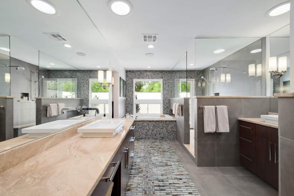 На фото: главная ванная комната в современном стиле с плоскими фасадами, темными деревянными фасадами, накладной ванной, душем в нише, коричневой плиткой, серой плиткой, разноцветной плиткой, белой плиткой, удлиненной плиткой, белыми стенами, настольной раковиной, мраморной столешницей, открытым душем, бежевой столешницей, тумбой под две раковины и встроенной тумбой