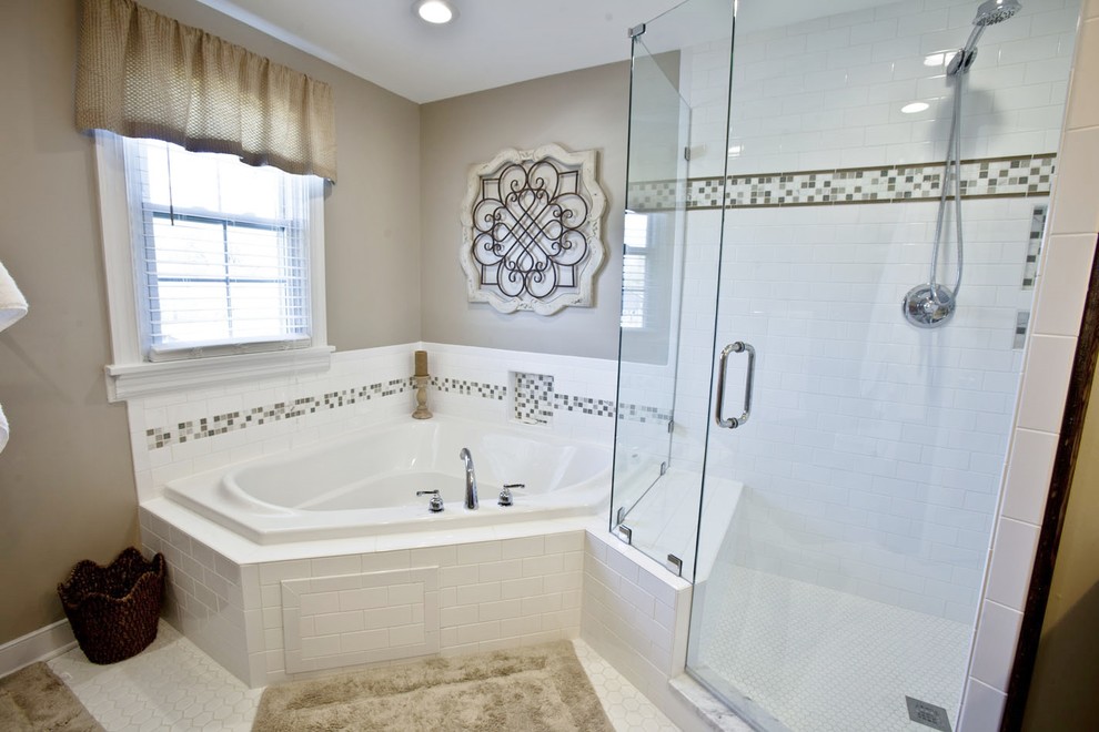 This is an example of a mid-sized traditional master bathroom in Richmond with recessed-panel cabinets, dark wood cabinets, a corner tub, a corner shower, multi-coloured tile, white tile, beige walls, porcelain floors, an undermount sink, marble benchtops, white floor, a hinged shower door and grey benchtops.