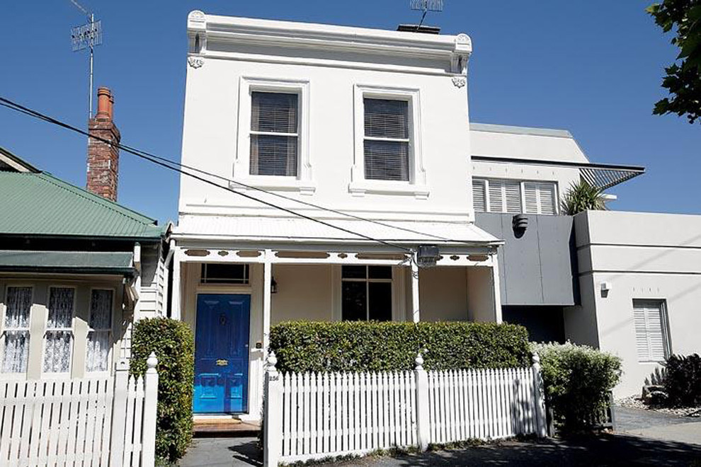 This is an example of an eclectic two-storey white house exterior in Other with a metal roof.