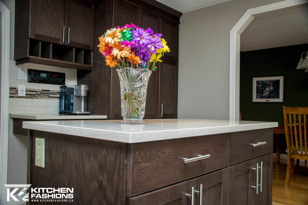 Inspiration for a mid-sized transitional l-shaped enclosed kitchen remodel in Toronto with an undermount sink, shaker cabinets, dark wood cabinets, quartz countertops, multicolored backsplash, subway tile backsplash, stainless steel appliances and an island