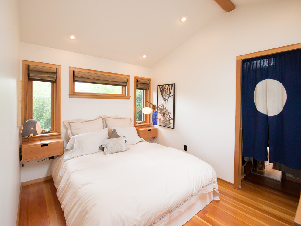 This is an example of an asian bedroom in Portland with white walls, medium hardwood floors and brown floor.