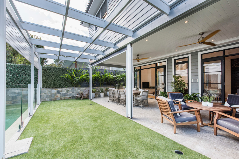 Small contemporary backyard patio in Brisbane with an outdoor kitchen, tile and a roof extension.