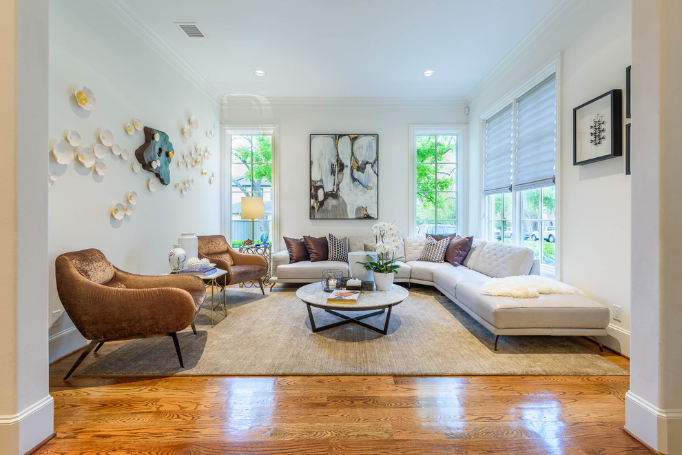 This is an example of a large transitional formal enclosed living room in Dallas with beige walls, light hardwood floors, no fireplace, no tv and brown floor.