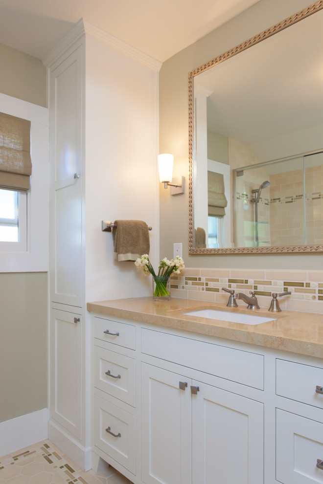 Design ideas for a mid-sized beach style master bathroom in San Francisco with an undermount sink, shaker cabinets, white cabinets, limestone benchtops, a shower/bathtub combo, a one-piece toilet, green tile, porcelain tile, beige walls and porcelain floors.