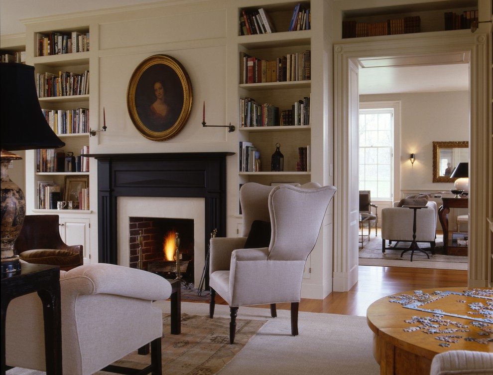 This is an example of a traditional enclosed family room in DC Metro with white walls, a standard fireplace and no tv.