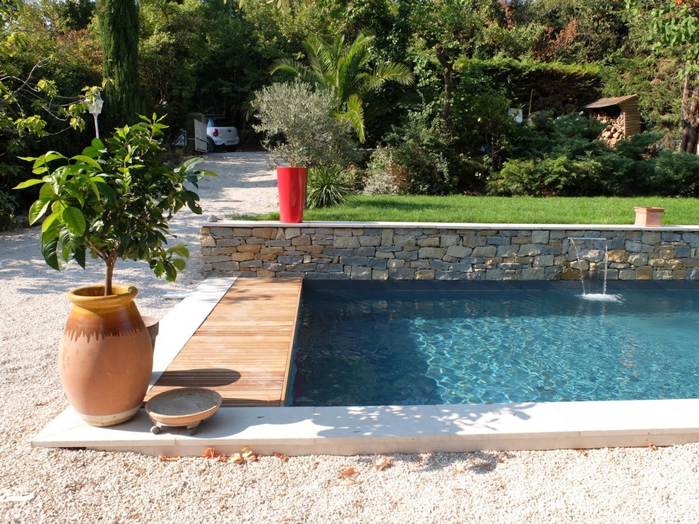 Photo of a mid-sized contemporary front yard rectangular pool in Marseille with gravel.