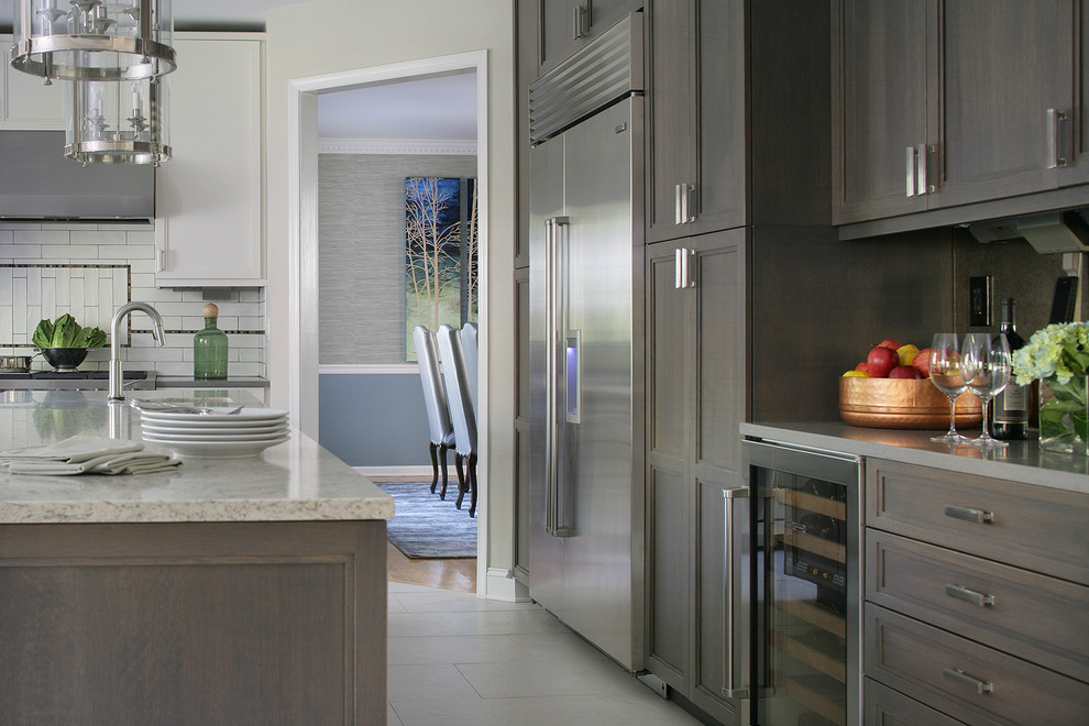 Eat-in kitchen - mid-sized transitional l-shaped porcelain tile eat-in kitchen idea in New York with recessed-panel cabinets, white backsplash, subway tile backsplash, stainless steel appliances, an island, an undermount sink and gray cabinets