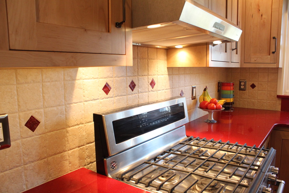 Example of a mid-sized mountain style l-shaped laminate floor enclosed kitchen design in Philadelphia with a double-bowl sink, shaker cabinets, light wood cabinets, quartz countertops, beige backsplash, ceramic backsplash, stainless steel appliances and no island