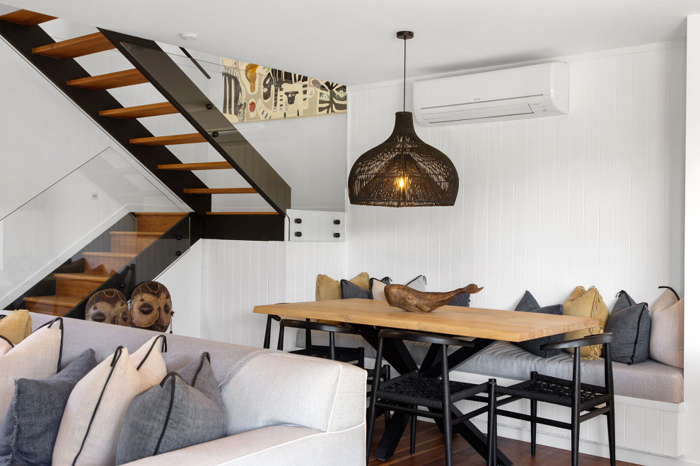 Idée de décoration pour une petite salle à manger marine avec une banquette d'angle, un mur blanc, parquet clair, un sol marron, un plafond voûté et du lambris de bois.