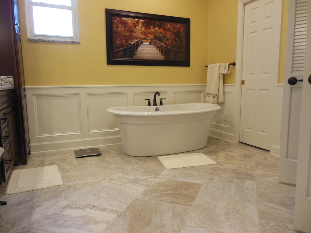 This is an example of a traditional bathroom in Tampa with beaded inset cabinets, brown cabinets, a freestanding tub, an open shower, yellow walls, cement tiles and marble benchtops.