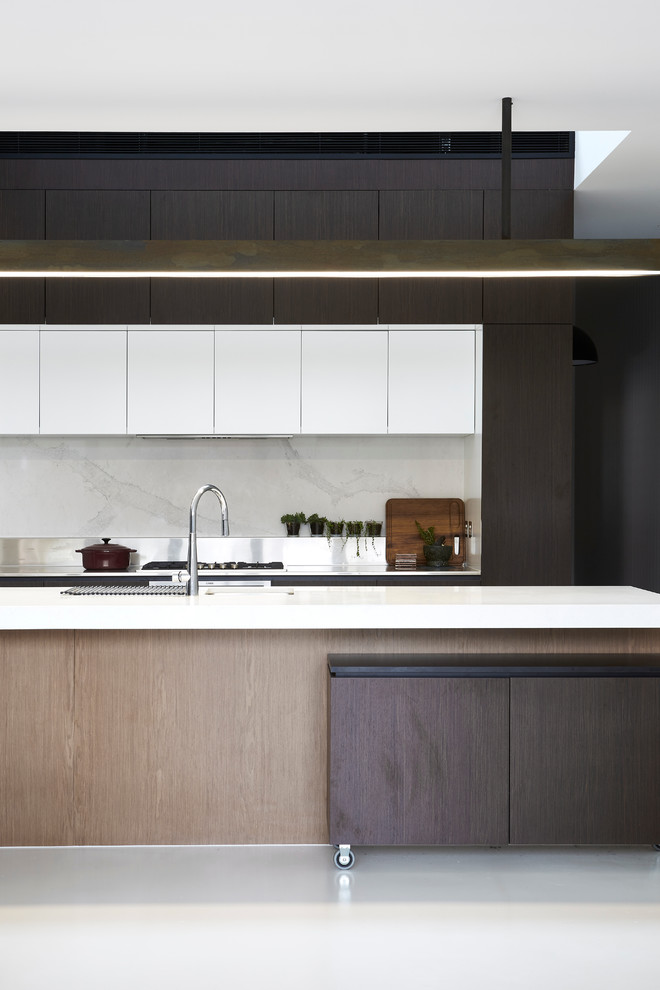 Design ideas for a mid-sized contemporary galley eat-in kitchen in Melbourne with an undermount sink, flat-panel cabinets, brown cabinets, stainless steel benchtops, white splashback, stone slab splashback, stainless steel appliances, concrete floors and with island.