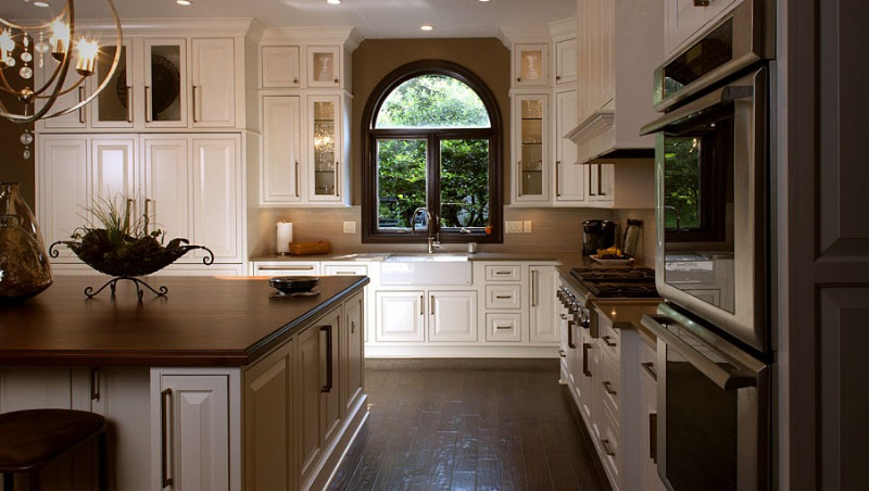 Eat-in kitchen - large l-shaped dark wood floor eat-in kitchen idea in Miami with a farmhouse sink, beaded inset cabinets, white cabinets, solid surface countertops, beige backsplash, stainless steel appliances and an island