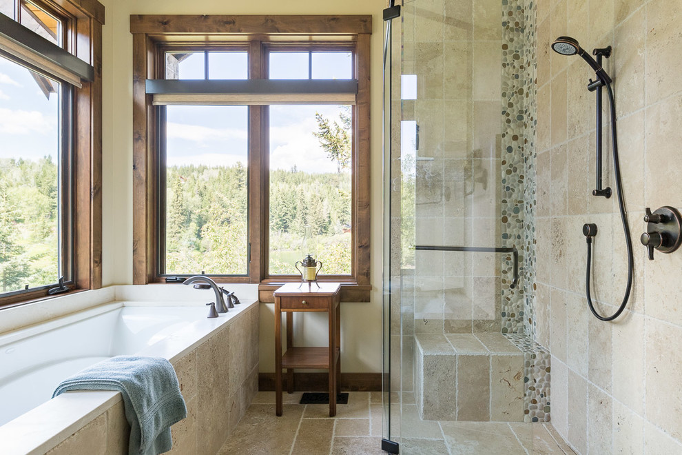 This is an example of a mid-sized country master bathroom in Jackson with furniture-like cabinets, brown cabinets, an undermount tub, a curbless shower, a two-piece toilet, beige tile, porcelain tile, beige walls, porcelain floors, a drop-in sink, marble benchtops, beige floor, a hinged shower door and beige benchtops.