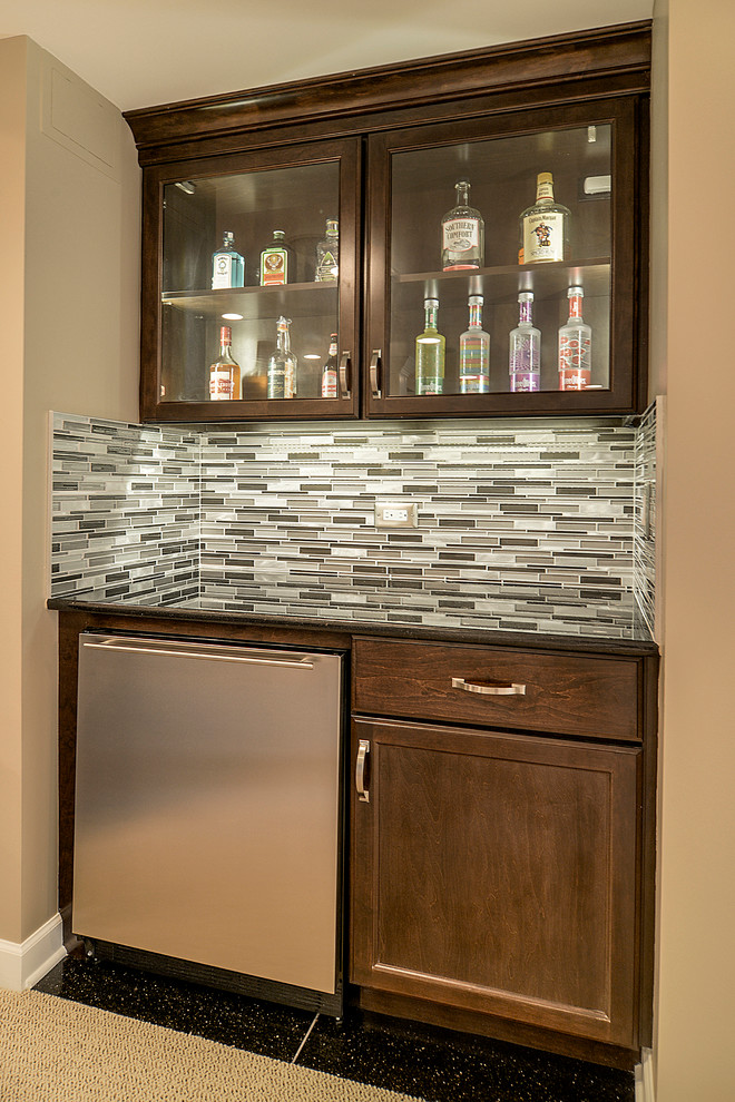 This is an example of a small transitional single-wall home bar in Nashville with shaker cabinets, dark wood cabinets, granite benchtops, multi-coloured splashback, marble floors and matchstick tile splashback.