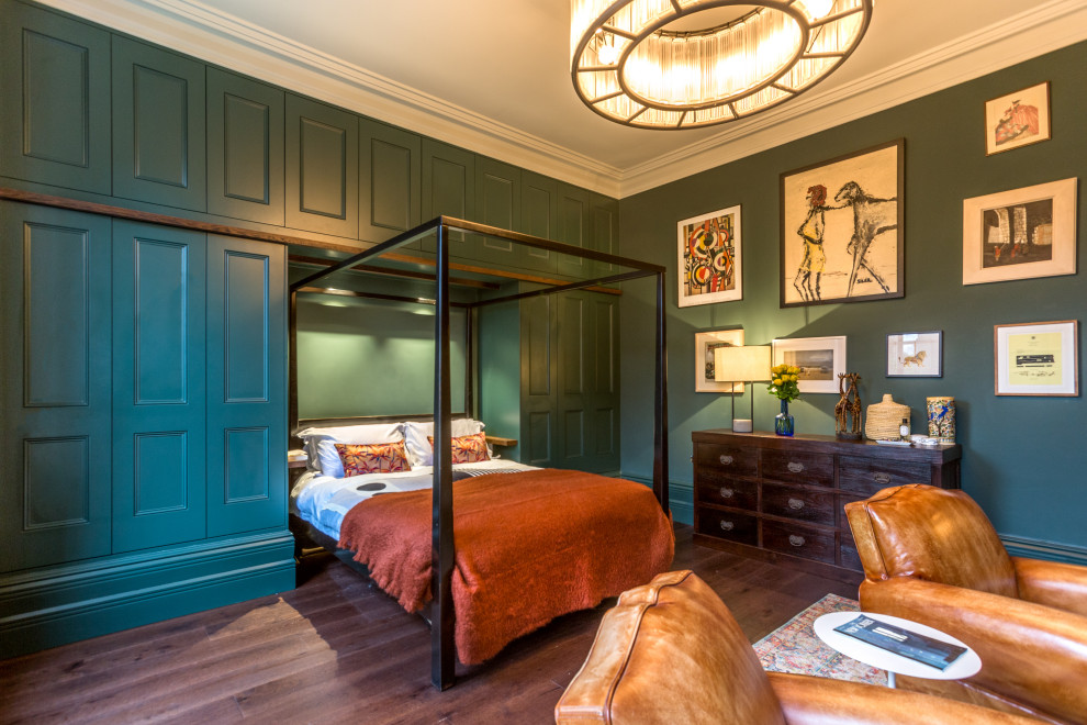 Design ideas for a large traditional master bedroom in London with green walls, dark hardwood floors and brown floor.