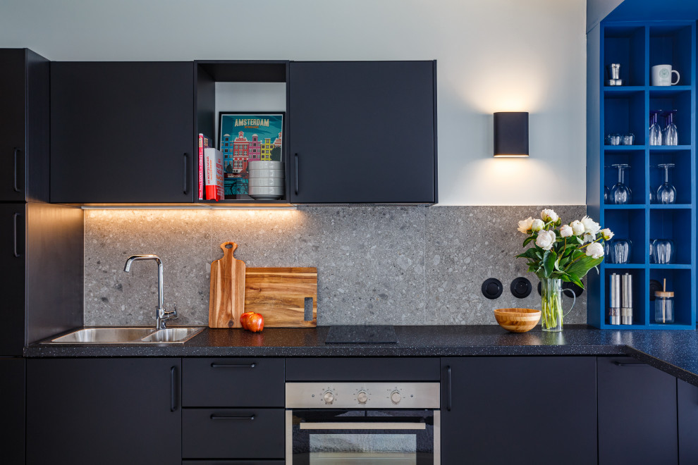 Photo of a small contemporary u-shaped open plan kitchen in Paris with a double-bowl sink, flat-panel cabinets, black cabinets, laminate countertops, grey splashback, ceramic splashback, integrated appliances, laminate floors, an island, brown floors and black worktops.