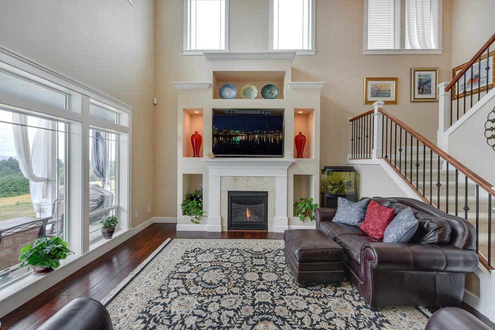 Large country open concept family room in Portland with beige walls, medium hardwood floors, a standard fireplace, a tile fireplace surround and a wall-mounted tv.