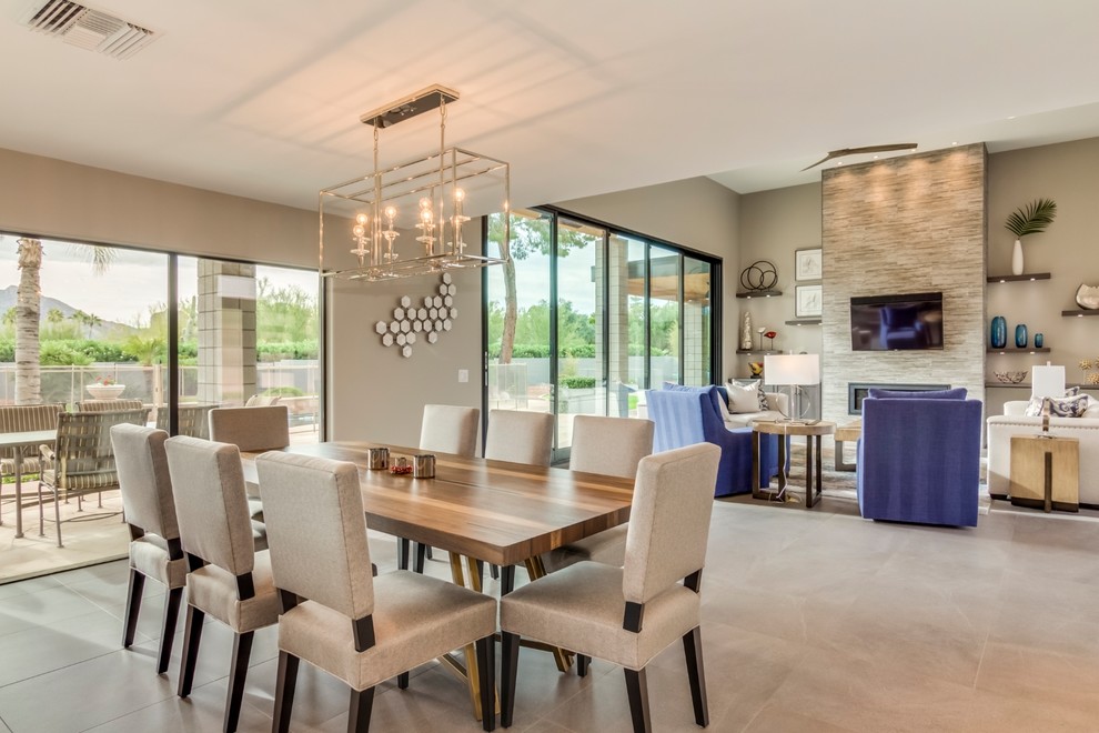 Large contemporary dining room in Phoenix with grey walls, porcelain floors, a tile fireplace surround and grey floor.
