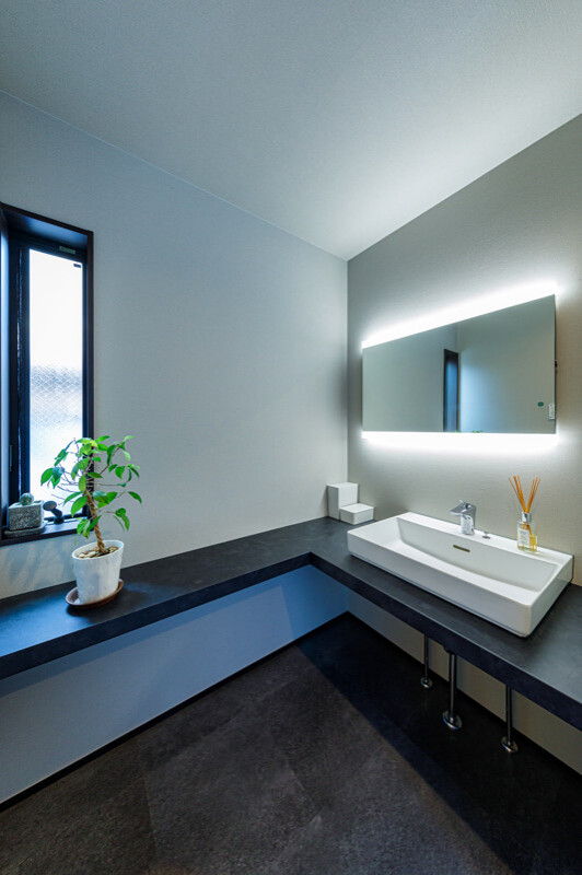 Idéer för mellanstora funkis svart toaletter, med vita skåp, grå kakel, grå väggar, ett fristående handfat och svart golv