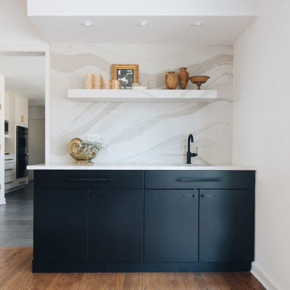 This is an example of a modern home bar in Chicago with an undermount sink, black cabinets, quartz benchtops, white splashback, engineered quartz splashback and white benchtop.