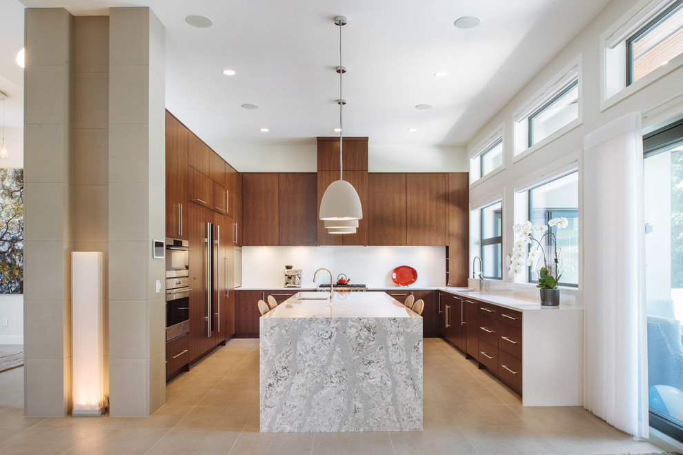 Photo of a large contemporary u-shaped kitchen in Vancouver with an undermount sink, medium wood cabinets, quartzite benchtops, white splashback, porcelain floors, with island, beige floor, flat-panel cabinets and panelled appliances.