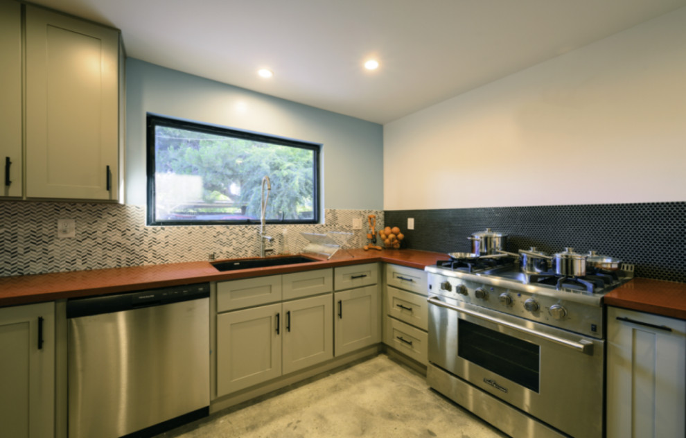 Example of a mid-sized 1960s l-shaped ceramic tile and beige floor eat-in kitchen design in Los Angeles with a double-bowl sink, shaker cabinets, white cabinets, granite countertops, blue backsplash, ceramic backsplash, stainless steel appliances, orange countertops and no island