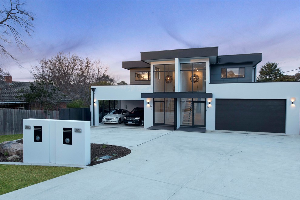 Design ideas for a mid-sized modern two-storey stucco grey duplex exterior in Canberra - Queanbeyan with a flat roof and a metal roof.
