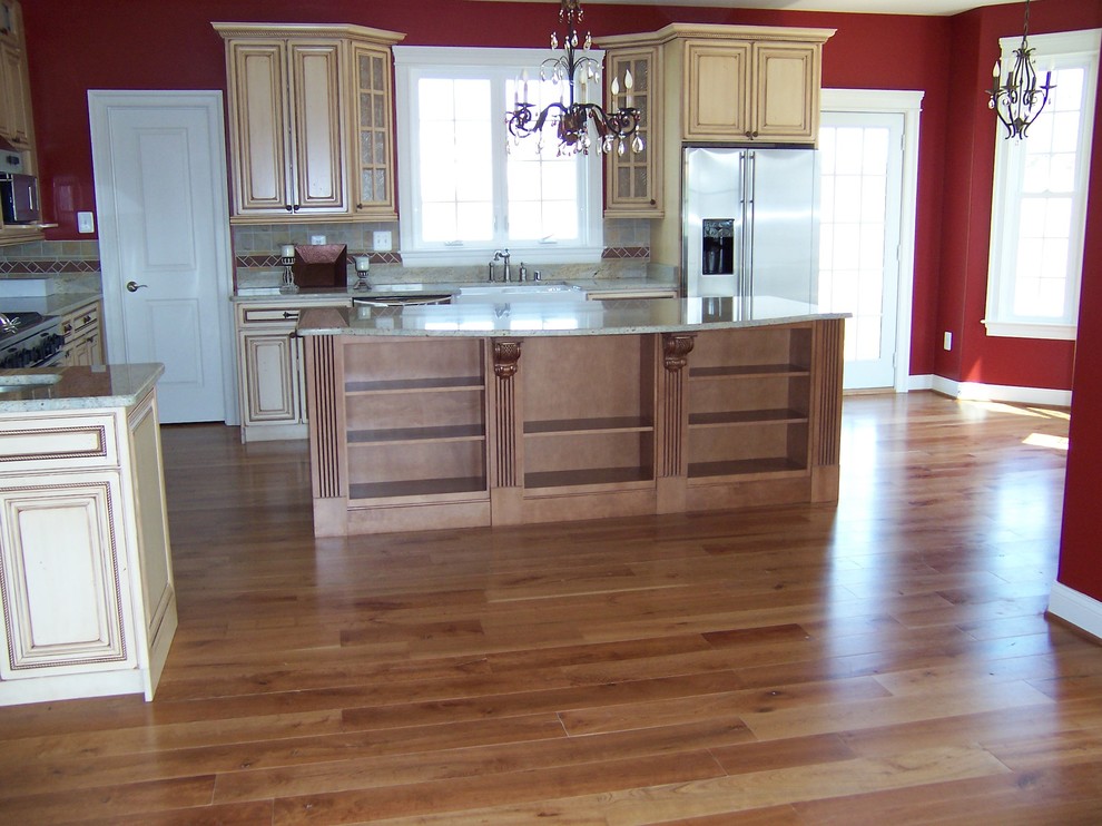 Example of a mountain style medium tone wood floor kitchen design in DC Metro with beaded inset cabinets, light wood cabinets, granite countertops, gray backsplash, terra-cotta backsplash, stainless steel appliances and an island