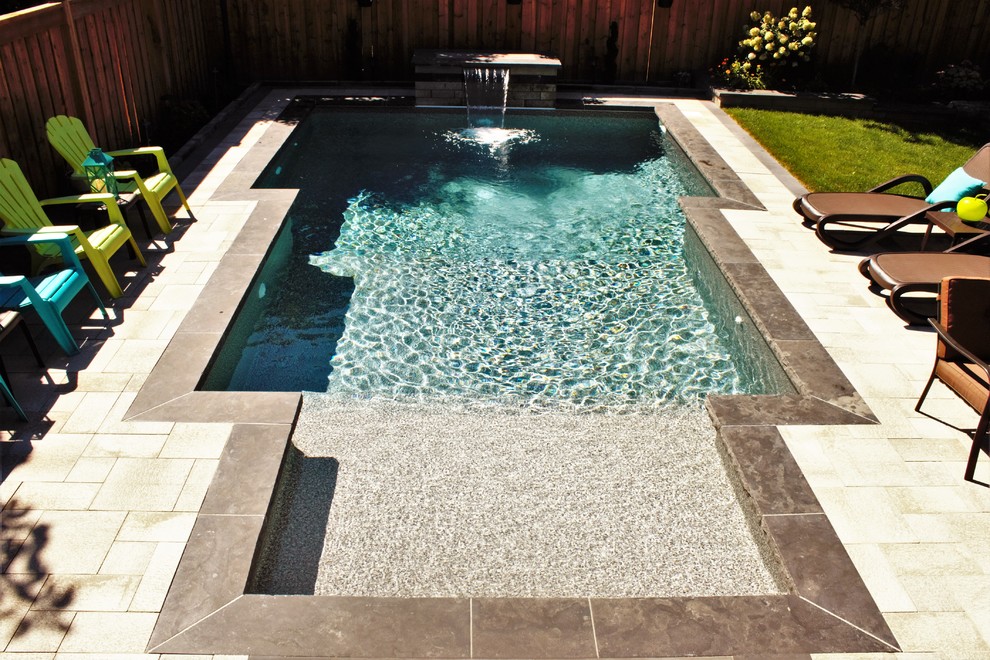 Pool - mid-sized transitional backyard concrete paver and custom-shaped lap pool idea in Toronto