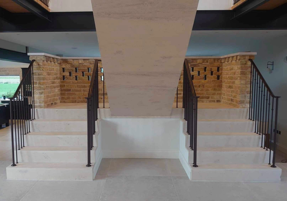 This is an example of a mid-sized modern travertine floating staircase in Other with travertine risers and metal railing.